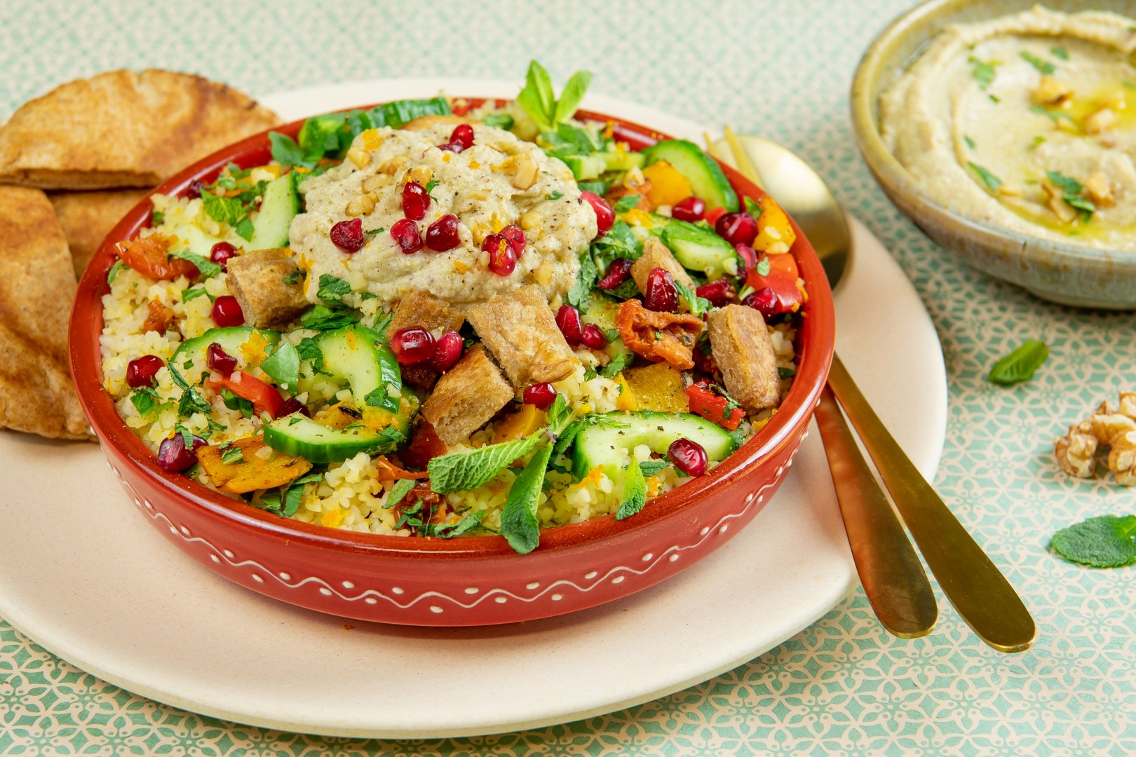 Bulgursalade met artisjokspread, gegrilde paprika, groene kruiden en gebakken pita